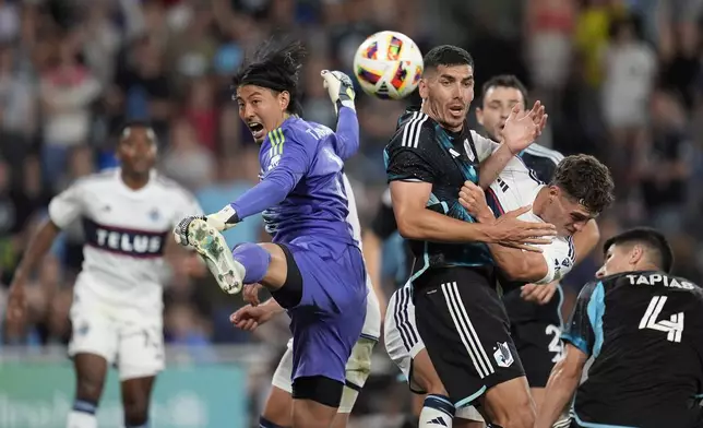 Vancouver Whitecaps goalkeeper Yohei Takaoka, center left, defends against a shot during the second half of an MLS soccer match against Minnesota United in St. Paul, Minn., Wednesday, July 3, 2024. (AP Photo/Abbie Parr)