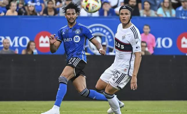 CF Montreal's Ariel Lassiter (11) plays a pass across the box as Vancouver Whitecaps' Bjorn Inge Utvik (15) look on during the second half of a MLS soccer game in Montreal, Saturday, July 6, 2024. (Graham Hughes/The Canadian Press via AP)