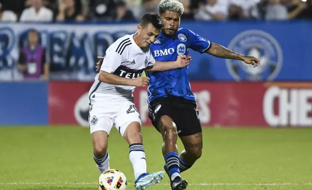 Vancouver Whitecaps midfielder Andres Cubas, left, challenges CF Montreal's Josef Martínez (17) during the second half of a MLS soccer game in Montreal, Saturday, July 6, 2024. (Graham Hughes/The Canadian Press via AP)