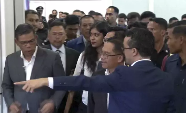 This grab taken from a video shows Malaysian officials receiving evacuees from Bangladesh, at the Kuala Lumpur International Airport, Malaysia, Tuesday July 23, 2024. Malaysia evacuated 123 of its citizens from Bangladesh on Tuesday in response to violent unrest that has killed dozens of people. (AP Photo)