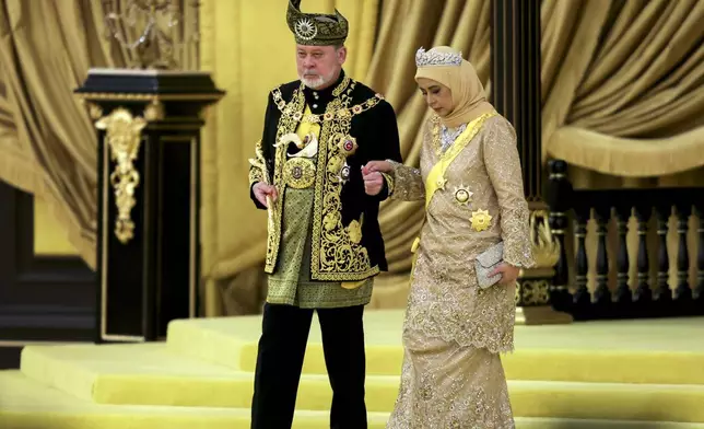 The 17th King of Malaysia, Sultan Ibrahim Iskandar, left, and Queen Raja Zarith Sofiah walk near the throne during his coronation at the National Palace in Kuala Lumpur, Malaysia, Saturday, July 20, 2024. (Hasnoor Hussain/Pool Photo via AP)