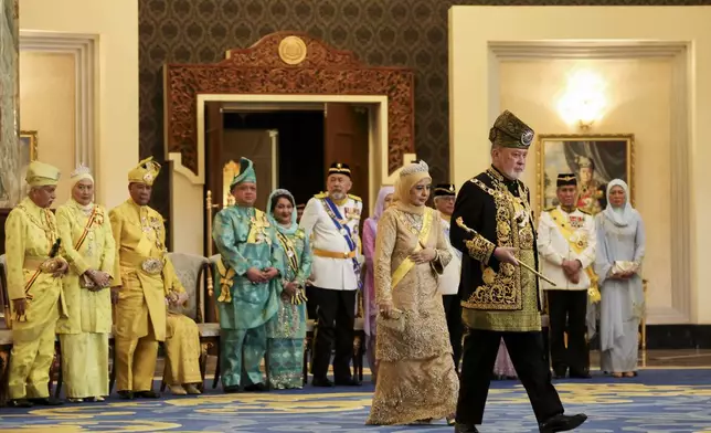 The 17th King of Malaysia, Sultan Ibrahim Iskandar, right, and Queen Raja Zarith Sofiah, center, walk away after his coronation at the National Palace in Kuala Lumpur, Malaysia, Saturday, July 20, 2024. (Hasnoor Hussain/Pool Photo via AP)