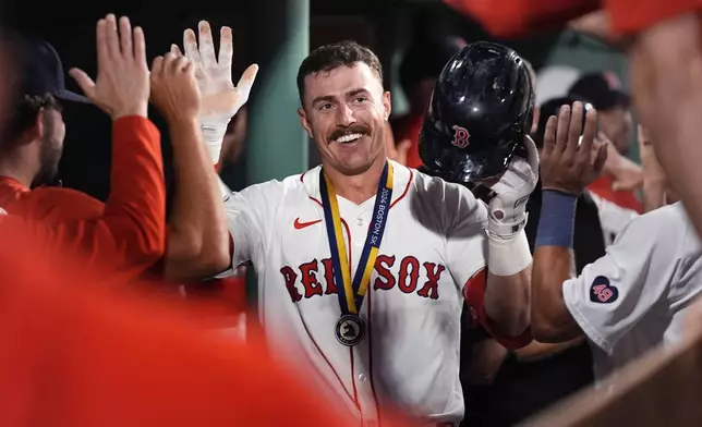 Boston Red Sox's Romy Gonzalez is congratulated after his two-run home run during the sixth inning of a baseball game against the Seattle Mariners, Monday, July 29, 2024, in Boston. (AP Photo/Charles Krupa)