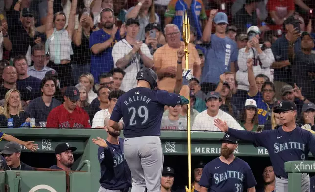 Seattle Mariners' Cal Raleigh (29) raises a trident while celebrating after his solo home run off Boston Red Sox pitcher Nick Pivetta during the sixth inning of a baseball game, Monday, July 29, 2024, in Boston. (AP Photo/Charles Krupa)