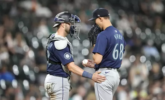 Seattle Mariners catcher Mitch Garver, left, talks with starting pitcher George Kirby, right, during the seventh inning of a baseball game against the Chicago White Sox, Friday, July 26, 2024, in Chicago. (AP Photo/Charles Rex Arbogast)