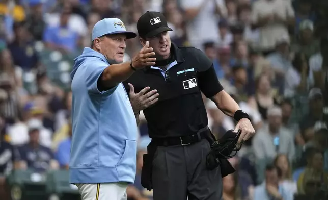 Milwaukee Brewers manager Pat Murphy, left, talks with an umpire, right, during the second inning of a baseball game against the Miami Marlins, Friday, July 26, 2024, in Milwaukee. (AP Photo/Aaron Gash)