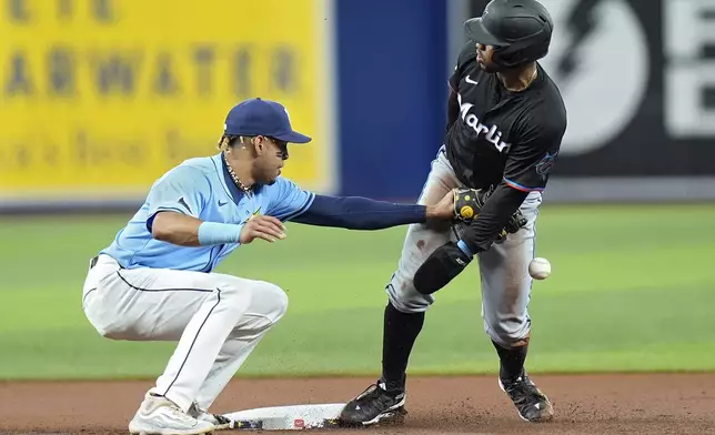 Tampa Bay Rays second baseman Christopher Morel, left, drops the ball as Miami Marlins' Xavier Edwards steals second base during the first inning of a baseball game Tuesday, July 30, 2024, in St. Petersburg, Fla. (AP Photo/Christopher O'Meara)