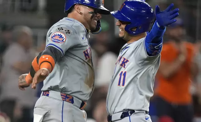 New York Mets' Francisco Alvarez, left, celebrates with teammate Jose Iglesias, right, after Iglesias hit a two-run home run during the 10th inning of a baseball game at Nationals Park, Monday, July 1, 2024, in Washington. (AP Photo/Mark Schiefelbein)