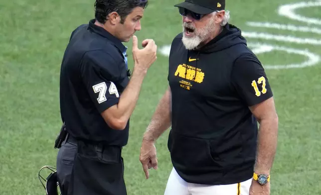 Pittsburgh Pirates manager Derek Shelton, right, questions a ball and strike call by umpire John Tumpane, left, during the seventh inning of a baseball game against the New York Mets in Pittsburgh, Saturday, July 6, 2024. Shelton was ejected for his protest. (AP Photo/Gene J. Puskar)