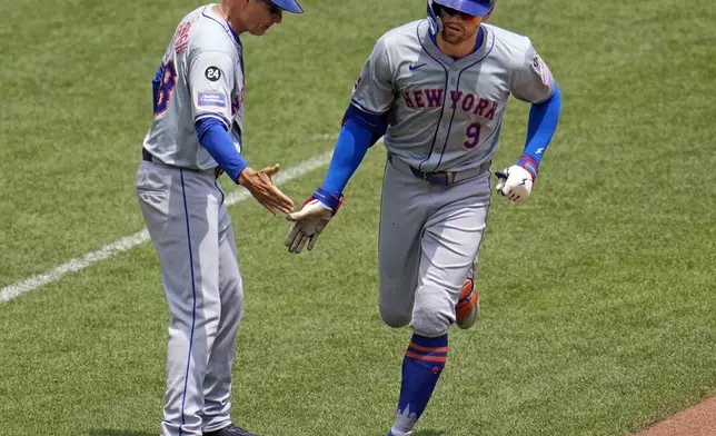 New York Mets' Brandon Nimmo (9) is greeted by third base coach Mike Sarbaugh as he rounds third base after hitting a two-run home run off Pittsburgh Pirates starting pitcher Mitch Keller during the sixth inning of a baseball game in Pittsburgh, Monday, July 8, 2024. (AP Photo/Gene J. Puskar)