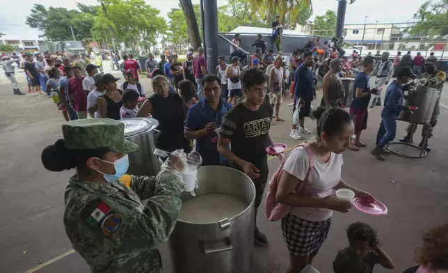 People line up to receive food at an army-provided soup kitchen for those affected by Hurricane Beryl in Tulum, Mexico, Friday, July 5, 2024. (AP Photo/Fernando Llano)