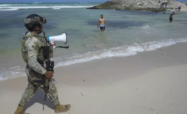 A soldier asks tourists to evacuate Mirador beach ahead of Hurricane Beryl's expected arrival, in Tulum, Mexico, Thursday, July 4, 2024. (AP Photo/Fernando Llano)