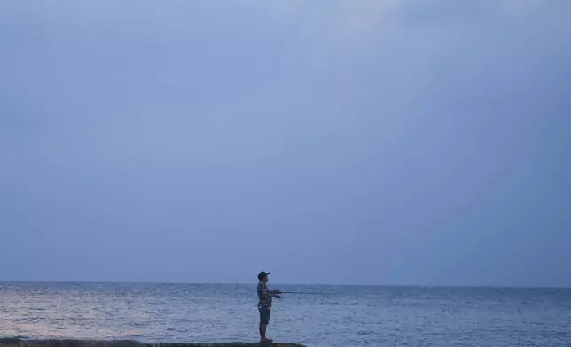 A man fishes in the sea ahead of Hurricane Beryl's expected arrival, in Playa del Carmen, Mexico, Wednesday, July 3, 2024. (AP Photo/Fernando Llano)