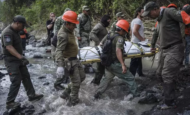 Rescuers recover the body of a policeman who state authorities said died in a car accident while checking damage caused by heavy rain in Alto Lucero, Veracruz, Mexico, Tuesday, July 2, 2024. (AP Photo/Felix Marquez)