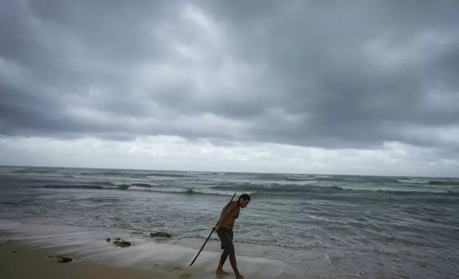 A man practices acrobatics with a pole on the beach in the aftermath by Hurricane Beryl in Tulum, Mexico, Friday, July 5, 2024. (AP Photo/Fernando Llano)