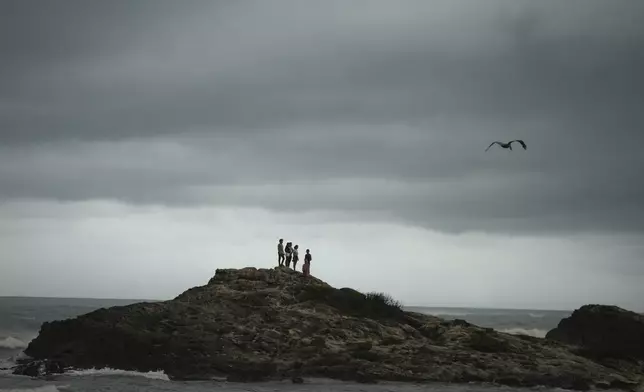 People stand on a rocky outcrop in the aftermath of Hurricane Beryl in Tulum, Mexico, Friday, July 5, 2024. (AP Photo/Fernando Llano)