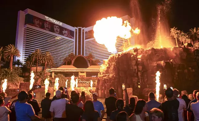 People watch the final scheduled volcano show during the final night of operations and gaming at The Mirage on Tuesday, July 16, 2024, in Las Vegas. (Chase Stevens/Las Vegas Review-Journal via AP)