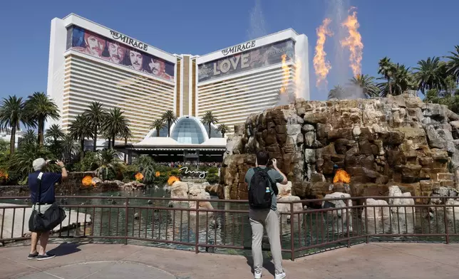 Tourists take video of the final "volcano eruption" show in front of the Mirage hotel-casino before the casino was closed Wednesday, July 17, 2024, in Las Vegas. (Steve Marcus/Las Vegas Sun via AP)