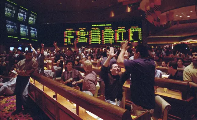 FILE - Dallas Cowboys' fans Tom Connolly, left, and Eddie Hidalgo, of Los Angeles, celebrate in the Mirage hotel and casino's sports book after winning one of their bets on the Super Bowl Sunday, Jan. 28, 1996, in Las Vegas. Gambling ends Wednesday, July 17, 2024, and the doors will close at The Mirage, the iconic tropical island-themed Las Vegas Strip hotel-casino that sparked a resort building boom when it opened in 1989 but became overshadowed while Sin City converted from a desert gambling hub to a worldwide entertainment destination.(AP Photo/Lennox McLendon)