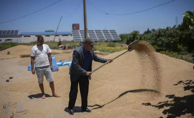 Abdelkrim Naaman, the chairman of the NGO Nalsya, right, advises a farmer on seeding, irrigation and drought mitigation, on a farm on the outskirts of Kenitra, Morocco, Friday, June 21, 2024. (AP Photo)