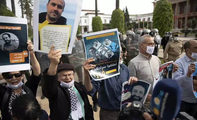 FILE - People carry banners and chant slogans during a protest calling for the release of detained journalists Omar Radi and Soulaimane Raissouni, in downtown Rabat, Morocco, Tuesday, May 25, 2021. Morocco’s King Mohammed VI on Monday, July 29, 2024, pardoned three journalists, including Radi and Raissouni, who were charged with sex crimes and espionage in prosecutions widely condemned by press freedom advocates as retaliatory in response to critical reporting. (AP Photo/Mosa'ab Elshamy, File)