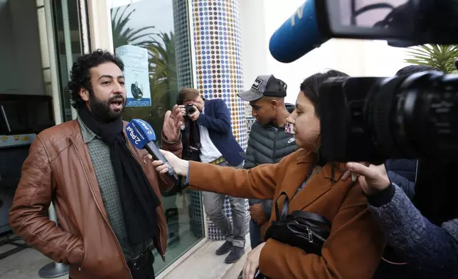 FILE - Journalist and activist Omar Radi speaks to the media after his hearing at the Casablanca Courthouse, In Casablanca, Morocco, Thursday March 5, 2020. Morocco’s King Mohammed VI on Monday, July 29, 2024, pardoned three journalists, including Radi, who were charged with sex crimes and espionage in prosecutions widely condemned by press freedom advocates as retaliatory in response to critical reporting. (AP Photo/Abdeljalil Bounhar, File)