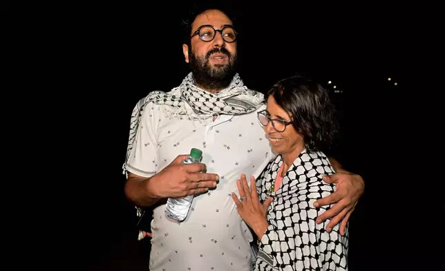 Omar Radi, a journalist and activist, left, is embraced by a family member after he was released from prison in Tifelt, Morocco, Monday, July 29, 2024. Morocco's King Mohammed VI on Monday pardoned a group of journalists who were charged with sex crimes and espionage in prosecutions widely condemned by press freedom advocates as retaliatory in response to critical reporting. (AP Photo)