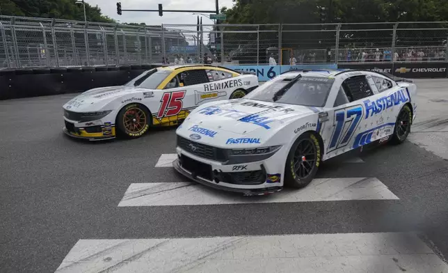 Denny Hamlin, left, and Chris Buescher round Turn 6 during a NASCAR Cup Series auto race, Sunday, July 7, 2024, in Chicago. (AP Photo/Erin Hooley)