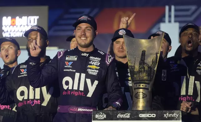 Alex Bowman stands with his team and his trophy after winning a NASCAR Cup Series auto race, Sunday, July 7, 2024, in Chicago. (AP Photo/Erin Hooley)