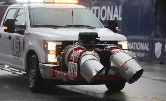 Rainwater is blown off the track during a NASCAR Cup Series auto race, Sunday, July 7, 2024, in Chicago. (AP Photo/Erin Hooley)