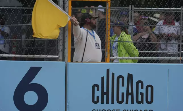 An official signals for drivers to slow down during a NASCAR Cup Series auto race, Sunday, July 7, 2024, in Chicago. (AP Photo/Erin Hooley)