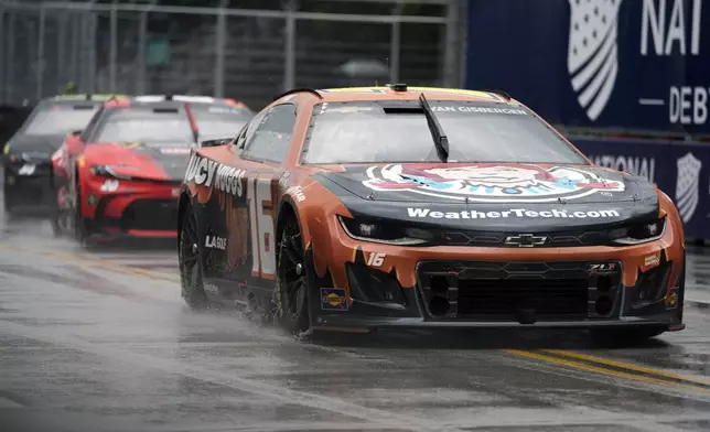 Shane van Gisbergen, right, and other drivers are forced to go at a slower pace as rain falls during a NASCAR Cup Series auto race, Sunday, July 7, 2024, in Chicago. (AP Photo/Erin Hooley)