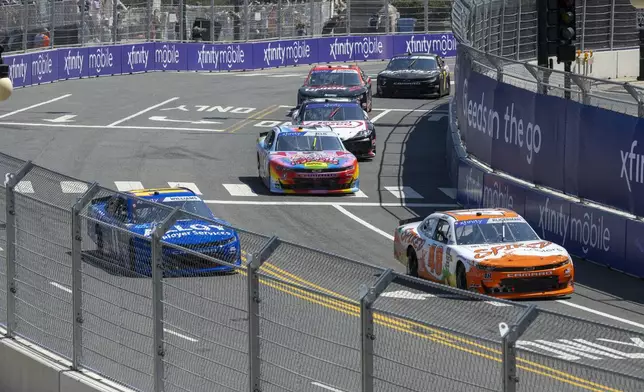 Cars navigate turn 19 during a NASCAR Xfinity Series street course auto race in Grant Park, Saturday, July 6, 202 4 in Chicago. (Tyler Pasciak LaRiviere/Chicago Sun-Times via AP)