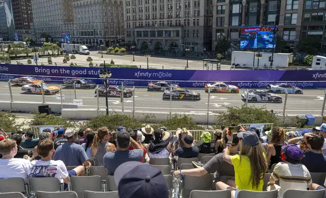 Fans watch as vehicles drive along Turn 19 during a NASCAR Xfinity Series street course auto race in Grant Park in Chicago, Saturday, July 6, 2024. (Tyler Pasciak LaRiviere/Chicago Sun-Times via AP)