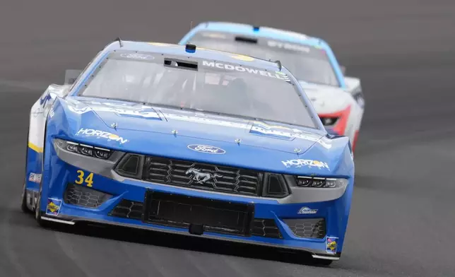 Michael McDowell drives into a turn during a NASCAR Cup Series auto race at Indianapolis Motor Speedway, Sunday, July 21, 2024, in Indianapolis. (AP Photo/Darron Cummings)