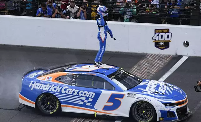 Kyle Larson celebrates after winning a NASCAR Cup Series auto race at Indianapolis Motor Speedway, Sunday, July 21, 2024, in Indianapolis. (AP Photo/Darron Cummings)