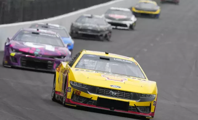 Joey Logano, front, drives into a turn during a NASCAR Cup Series auto race at Indianapolis Motor Speedway, Sunday, July 21, 2024, in Indianapolis. (AP Photo/Darron Cummings)