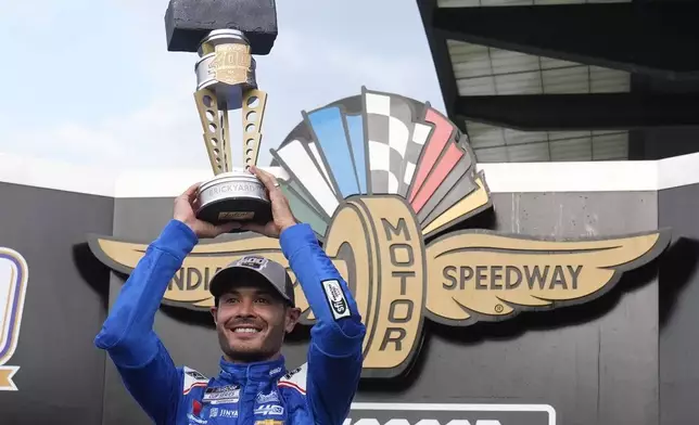 Kyle Larson holds the trophy after winning a NASCAR Cup Series auto race at Indianapolis Motor Speedway, Sunday, July 21, 2024, in Indianapolis. (AP Photo/Darron Cummings)