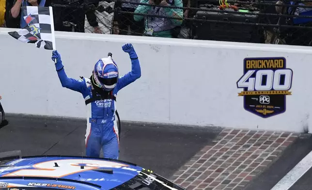 Kyle Larson celebrates after winning a NASCAR Cup Series auto race at Indianapolis Motor Speedway, Sunday, July 21, 2024, in Indianapolis. (AP Photo/Darron Cummings)