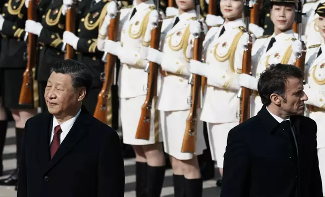 FILE - Chinese President Xi Jinping, left, and France's President Emmanuel Macron review troops during a welcome ceremony at the Great Hall of the People in Beijing, China, on April 6, 2023. France's President Emmanuel Macron has urged European nations to seek more independence on airspace defense and relocate production to the continent rather than purchasing material off the shelf from American arms merchants. (AP Photo/Thibault Camus, File)