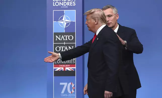 FILE - NATO Secretary General Jens Stoltenberg, right, directs U.S. President Donald Trump which way to step off the podium at a welcoming ceremony during a NATO leaders meeting at The Grove hotel and resort in Watford, Hertfordshire, England, on Dec. 4, 2019. When Donald Trump suggested during the 2016 presidential campaign that he might not honor a U.S. commitment to defend other NATO countries if they were attacked, it triggered alarm throughout the trans-Atlantic alliance. (AP Photo/Francisco Seco, File)