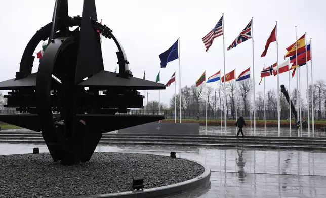 FILE - A man walks among flags of member countries as protocol prepare for a flag raising ceremony to mark the accession of Sweden at NATO headquarters in Brussels, Monday, March 11, 2024. U.S. President Joe Biden and his NATO counterparts are meeting in Washington this week to mark the 75th anniversary of the world's biggest security organization just as Russia presses its advantage on the battlefield in Ukraine. (AP Photo/Geert Vanden Wijngaert, File)