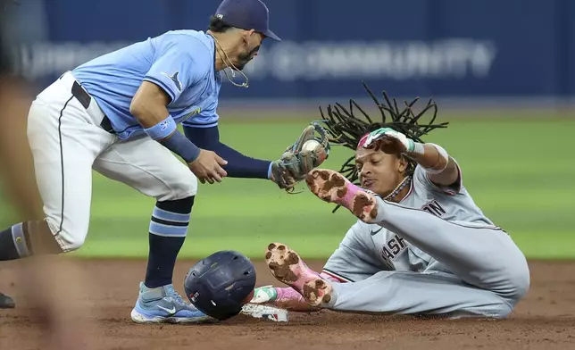Washington Nationals' CJ Abrams, right, steals second base past a tag by Tampa Bay Rays' Jose Caballero during the third inning of a baseball game Sunday, June 30, 2024, in St. Petersburg, Fla. (AP Photo/Mike Carlson)