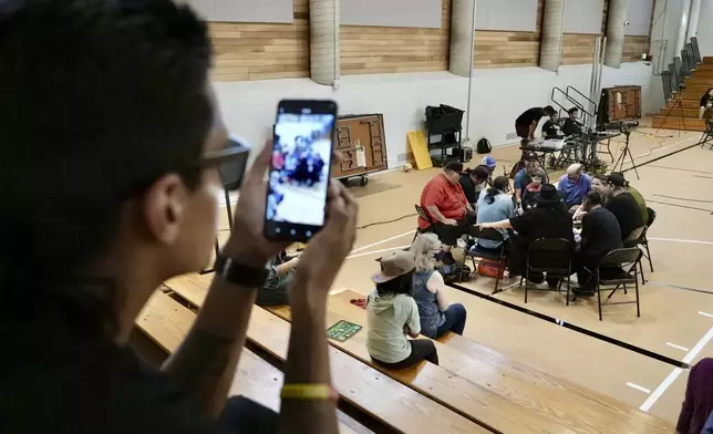 Jarvis Harrington shares a video of a drum and dance night at Minneapolis American Indian Center on Wednesday, July 10, 2024, in Minneapolis, Minn. Harrington, who tries to attend the performances each week, says the drums and song help him reconnect with this culture. (AP Photo/Mark Vancleave)