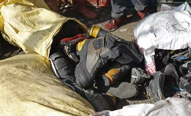 Shoes and other garbage collected en route Mount Everest is piled before it is sorted for recycling at a facility operated by Agni Ventures, an agency that manages recyclable waste, in Kathmandu, Nepal, Monday, June 24, 2024. The highest camp on the world's tallest mountain is littered with garbage that is going to take years to clean up, according to a Sherpa who led a team that worked to clear trash and dig up dead bodies frozen for years near Mount Everest's peak. (AP Photo/Sanjog Manandhar)