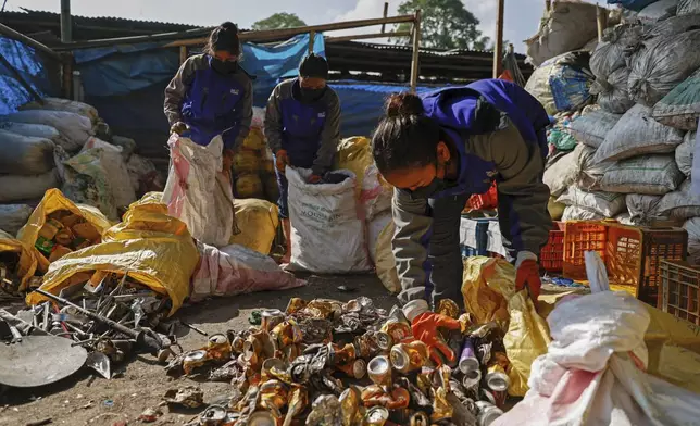 Workers segregate the garbage collected en route Mount Everest, at a facility operated by Agni Ventures, an agency that manages recyclable waste, in Kathmandu, Nepal, Monday, June 24, 2024. The Nepal government-funded team of soldiers and Sherpas removed 11 tons (24,000 pounds) of garbage, four dead bodies and a skeleton from Everest during this year's climbing season. (AP Photo/Sanjog Manandhar)