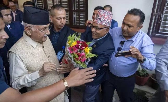 Khadga Prasad Oli, left, the chairman of the Communist Party of Nepal leaves his residence to meet his supporters after being appointed as Prime Minister, in Kathmandu, Nepal, Sunday, July 14, 2024. The leader of the Nepal's largest communist party, Khadga Prasad Oli, was named the Himalayan nation's new prime minister on Sunday following the collapse of a previous coalition government. (AP Photo/Niranjan Shrestha)