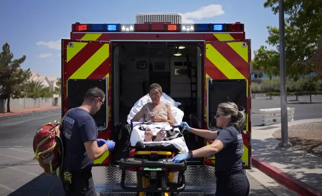 Members of the Henderson Fire Department load Deb Billet, 66, into an ambulance before transporting her to the hospital for heat-related symptoms, Wednesday, July 10, 2024, in Henderson, Nev. Billet has been living on the streets. (AP Photo/John Locher)