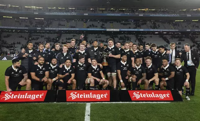 New Zealand's team pose with their trophy after defeating England in their rugby union test match in Auckland, New Zealand, Saturday, July 13, 2024. (Brett Phibbs/photosport via AP)