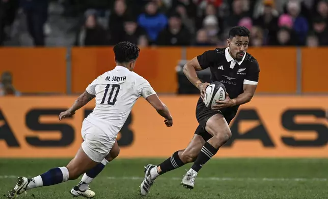 England's Marcus Smith, left, looks to tackle New Zealand's Stephen Perofeta during their rugby union test match in Dunedin, New Zealand, Saturday July 6, 2024. (Andrew Cornaga/Photosport via AP)